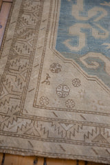 Detail of snowflake motifs and the serrated leaf border on a distressed Caucasian rug runner.