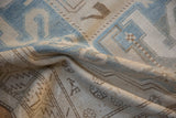 Evenly worn, low-pile texture of a vintage Caucasian rug in soft sky blue and beige.