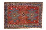 Vintage Persian Karaja rug with geometric diamond medallions in madder red, sky blue, and camel.