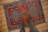 Vintage Karaja rug with red and blue geometric design, shown on floor for scale.