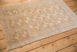 Distressed vintage Belouch rug with geometric pinwheels and multi-tiered borders in platinum, ivory.