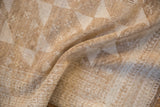 Worn texture of a distressed Belouch rug, revealing subtle geometric patterns in neutral tones.