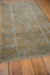 Angled view highlighting the abrashed coffee brown field and soft texture of this vintage Belouch rug.