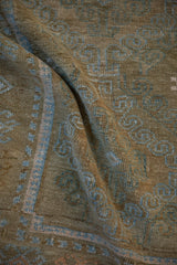 Draped vintage Persian rug showing its low, knotted pile in pale coffee brown and powder blue.