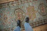 Time-softened colors and mostly even wear on the pile of a vintage Karaja runner.
