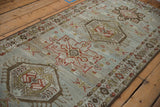 Angled view of the distressed Karaja runner's low pile, showing geometric medallions and a boteh border.