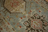 Geometric motifs in rust and brown on the time-softened powder blue pile of a Karaja rug.