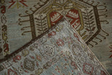 Folded corner of a distressed Karaja runner showing its hand-knotted weave and low pile.