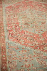 Angled view of the distressed, low pile with faded raspberry red and dusty sky blue Herati motifs.