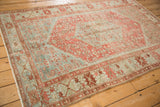 Angled view of a vintage distressed Malayer showing time-softened raspberry and powder blue tones.