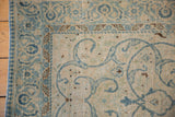 Distressed Tabriz rug corner with blue arabesques, worn beige field, blossom and pawn motif borders.