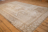Angled view of a distressed Kars carpet's abrashed field and large geometric shield medallion.