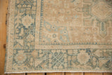 Low-pile texture and geometric border of a distressed Karaja rug in dusty teal and beige.