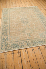 A vintage Karaja rug with a central medallion, sandy field, and contrasting dusty teal geometric border.