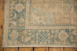 Close-up of a distressed Karaja rug corner showing even wear over dusty teal and sand motifs.