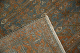 Folded corner of a vintage Malayer rug showing its secure side selvage and hand-knotted back.