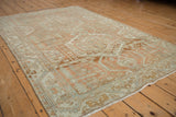 Angled view of the vintage Malayer rug showing its oversized terracotta medallion and low, even pile.