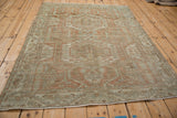 Full angled view of the distressed vintage Malayer rug showing its overall geometric pattern.