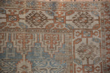 Distressed vintage Belouch runner detail, displaying worn geometric patterns in dusty blue and copper.