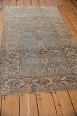 Faded geometric patterns in dusty blue and pale coffee brown on a distressed Belouch runner.