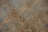 Distressed Belouch rug detail showing geometric pattern, visible knot heads, blue and brown.