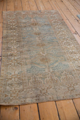 Faded geometric patterns in dusty blue and pale coffee on a distressed Belouch runner.