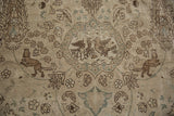 Distressed vintage Tabriz rug detail with hunting scene, birds, lions, and faded patterns.
