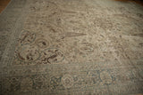Distressed Tabriz carpet border with pale blue and intricate field motifs, showing even wear.