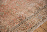 Intricate blossoms and vines in dusty blush and slate blue on a distressed vintage Bijar's low pile.