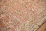 Angled detail of a vintage Persian rug's soft blush, sand, and slate blue floral pattern.