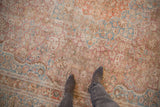Distressed vintage Meshed rug with faded raspberry, orange, blue floral patterns and mostly even wear.
