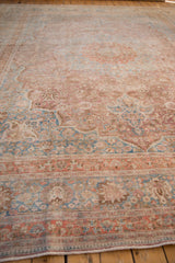 Distressed Persian Meshed rug edge, faded raspberry, sky blue, ivory palmette motifs.