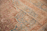 Distressed Meshed carpet featuring faded raspberry, sky blue, and orange palmette border.