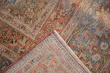 Vintage distressed Meshed carpet corner, revealing faded floral motifs and tight woven back.