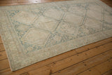 Decorative faded teal diamond lattice and ivory floral border with even wear.
