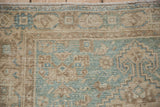 Worn, hand-knotted pile on a vintage Hamadan rug with dusty blue and sand geometric motifs.