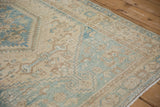 Angled corner view of the distressed Hamadan rug showing its low pile and geometric patterns.