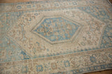 Worn pile and serrated blue medallion detail on a distressed vintage Hamadan rug.