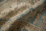 A soft fold reveals the low, even pile of a distressed Hamadan rug.