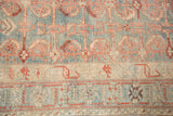 Intricate serrated leaf border and distressed low pile on a vintage Persian Mehriban rug.