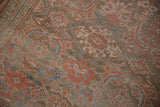 Herati design motifs in ruby red and blue on the rug's low, textured pile.