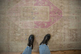 Detail of a distressed Bijar rug's low pile, with sand, pale magenta, and fuchsia accents.