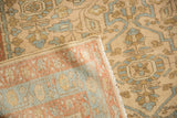 Flipped corner of a distressed Mehriban rug showing its hand-knotted back and low pile.