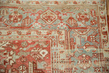 Distressed Heriz carpet corner with ruby red geometric blossoms, slate blue field, and prominent Turtle Samovar border.