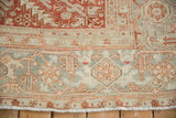 Distressed vintage Heriz carpet edge, featuring muted geometric Turtle Samovar border motifs and fringe.