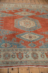 Angled view across the distressed Veece carpet, highlighting the worn, low-pile texture in cherry red and blue.