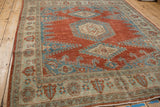 Angled view highlighting the time-softened tones and distressed texture of a vintage Persian Veece carpet.
