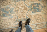 Low pile texture of a distressed Oushak rug with a denim blue shield medallion.