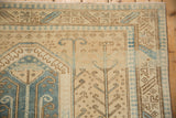Corner of a vintage Oushak rug showing the pawn motif border in soft blue, sand, and brown tones.
