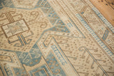 Close-up of a distressed Oushak rug's geometric pawn motifs in denim blue and sand tones.